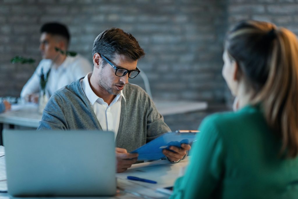 Insurance agent analyzing financial reports of his client during a meeting.