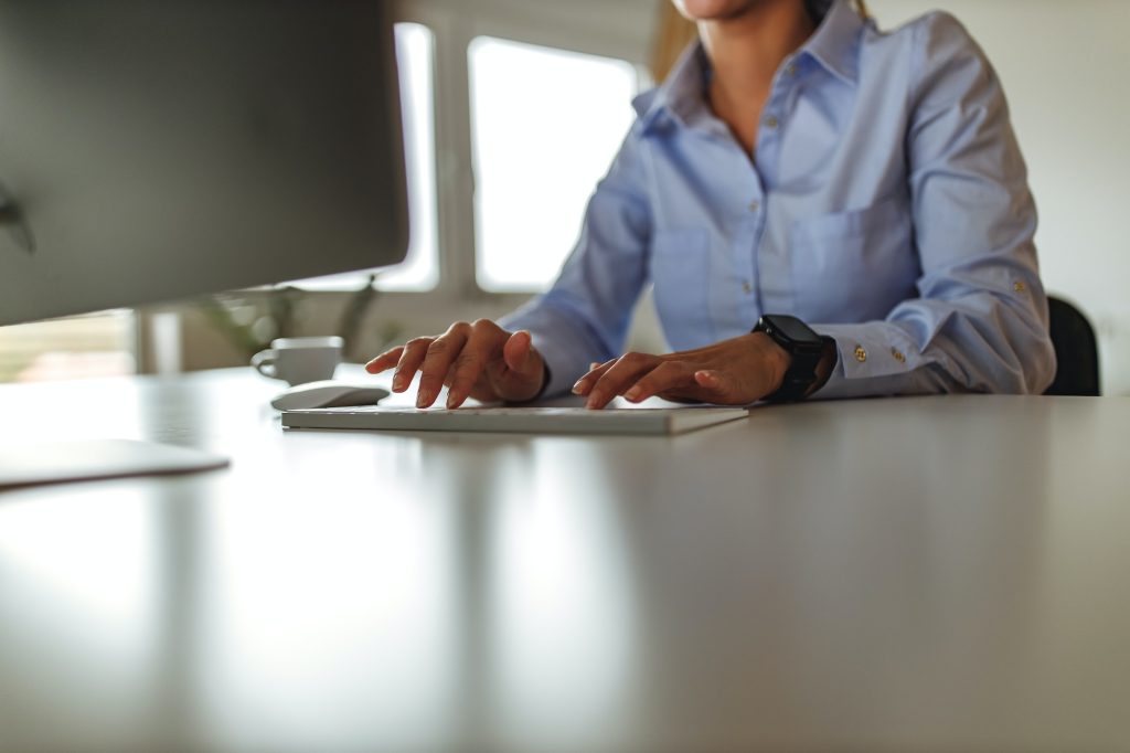 White desk, monitor in front of woman.